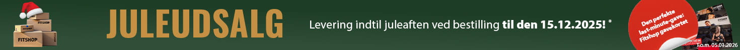 Et jule-reklamebanner med grøn baggrund og en lyskæde langs toppen. Til venstre ligger flere gaver med teksten “Fitshop”, og ved siden af dem ses flere Fitshop-gavekort. I et rødt fremhævet felt står der: “Den perfekte last-minute-gave: Fitshop-gavekortet.” Til højre står der med store bogstaver “Juleudsalg” samt teksten “Levering indtil juleaften ved bestilling til den 15.12.2025!*”.